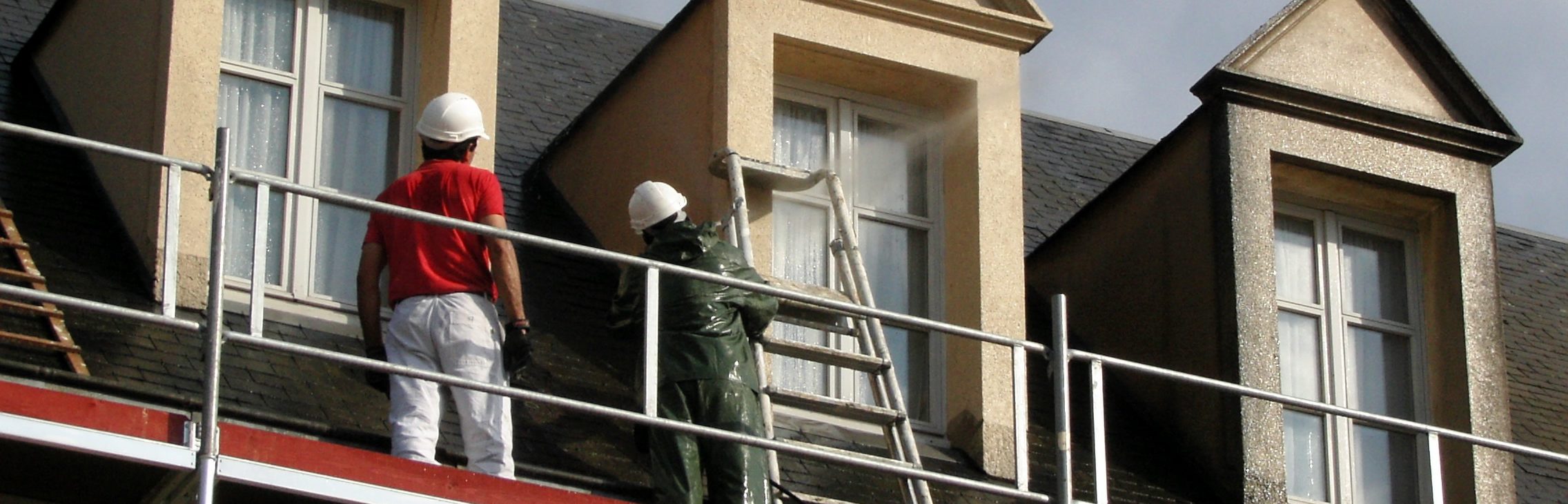 Ravalement d'une façade sale à l'aide d'un hydrofurge